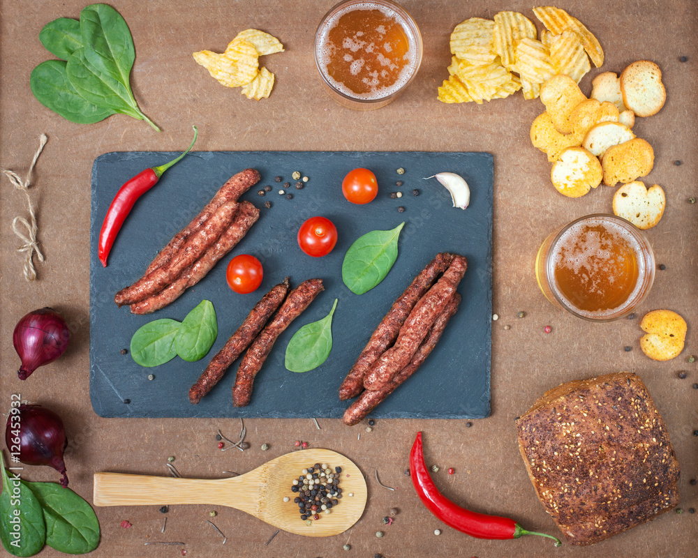 Grilled beef sausages with beer and snacks. Top view.