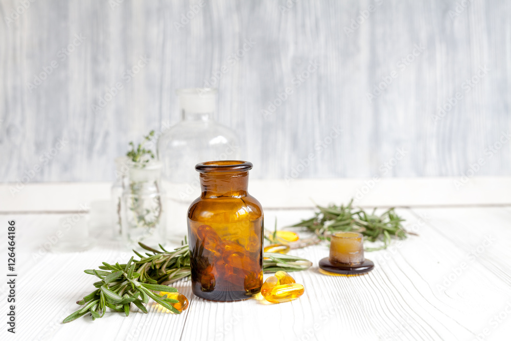 concept - natural medicine herbs in bottles on wooden background