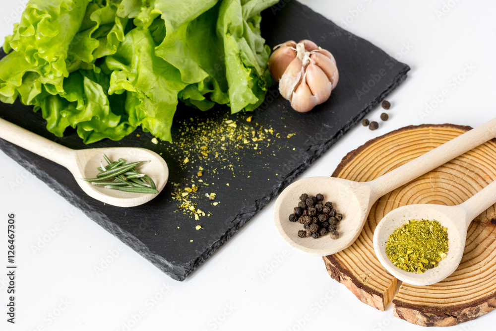 various spices in spoon with wooden stand on white background