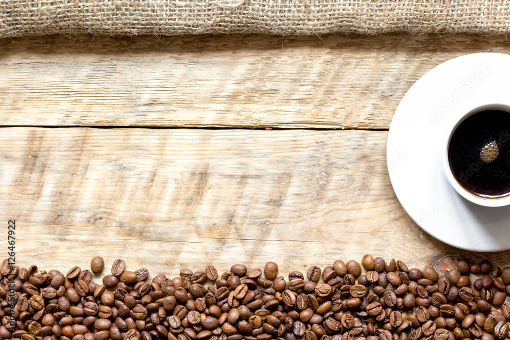 coffee beans with coffe cup on wooden table top view