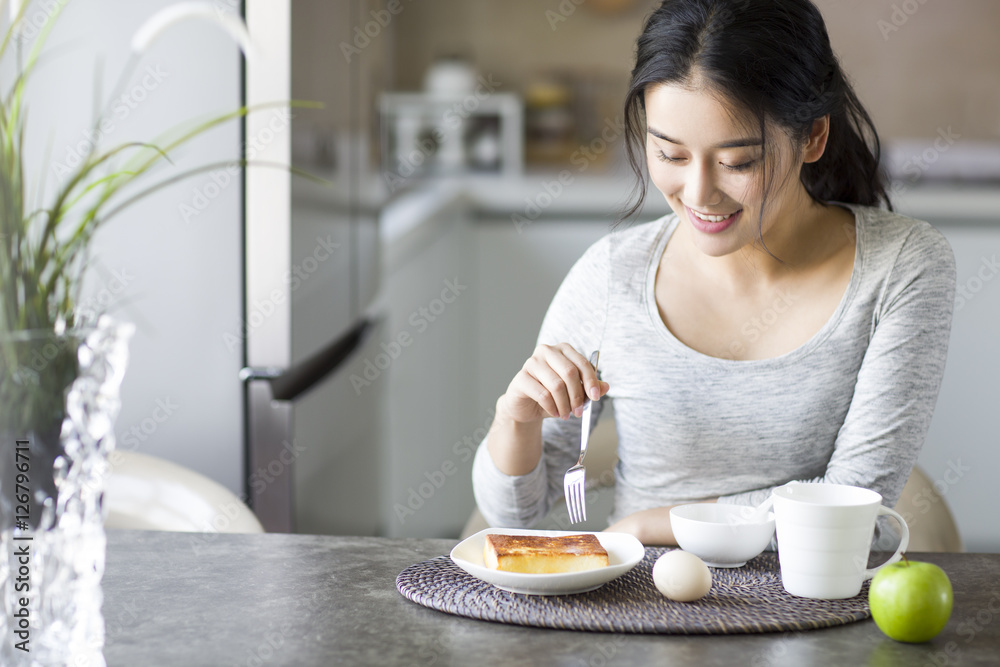 Young woman eating breakfast at home