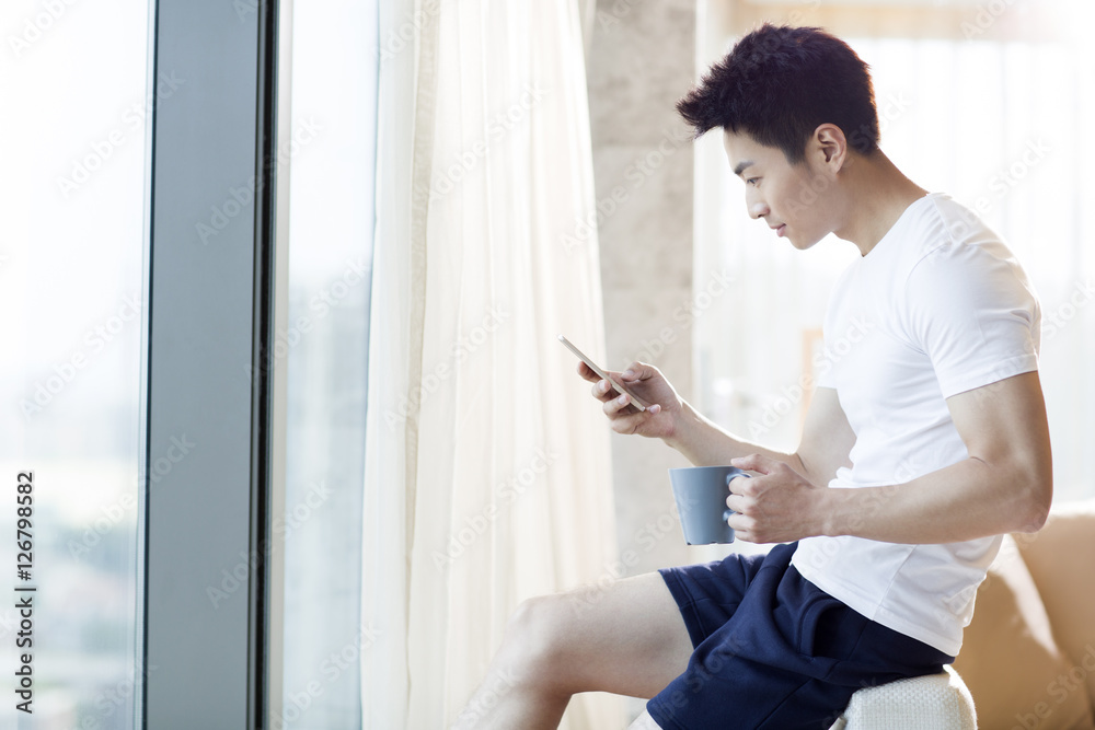 Young man using smart phone at home