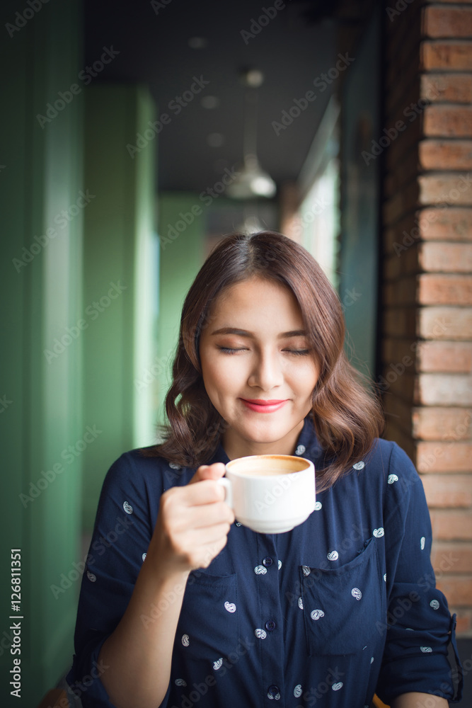 Portrait of happy young business woman with mug in hands drinkin