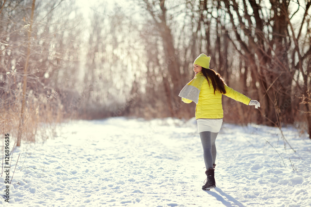 冬日快乐的女人在雪地里行走户外大自然。快乐的年轻女士在户外散步玩得很开心