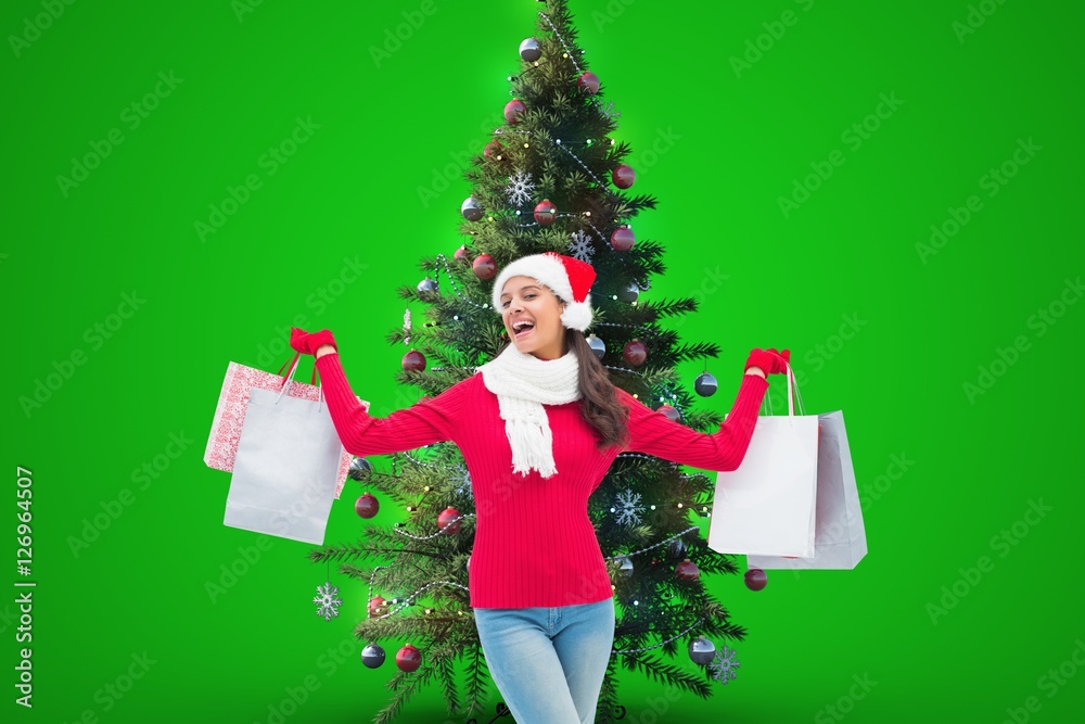 Woman holding shopping bags near christmas tree