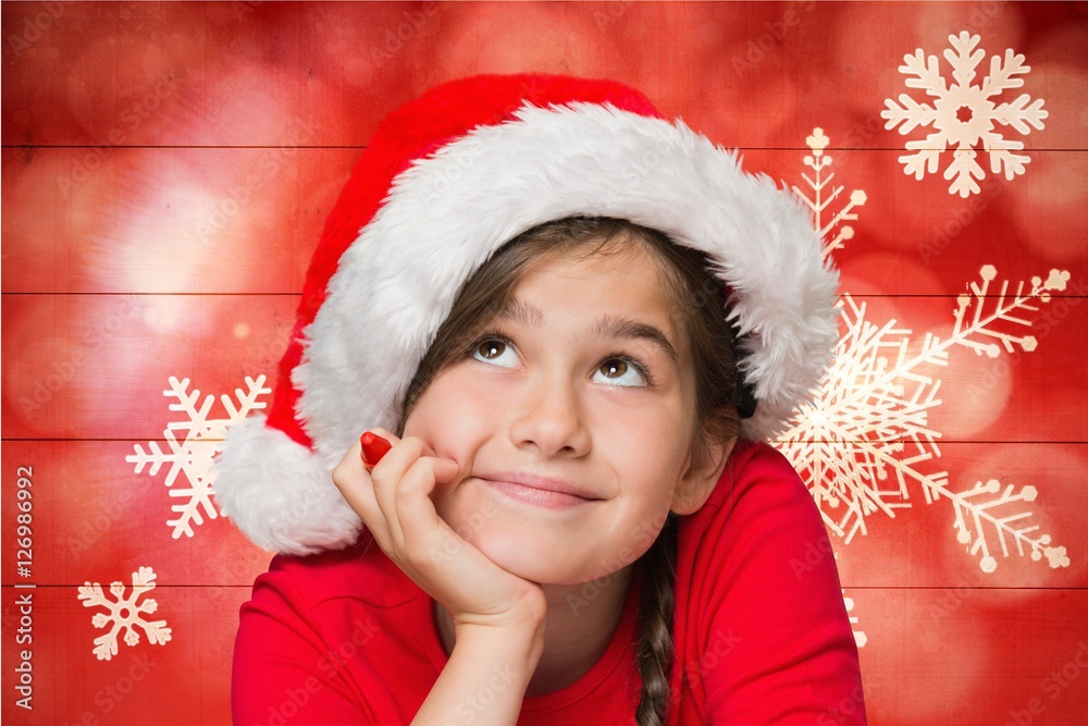 Thoughtful girl in santa hat against digitally generated backgro