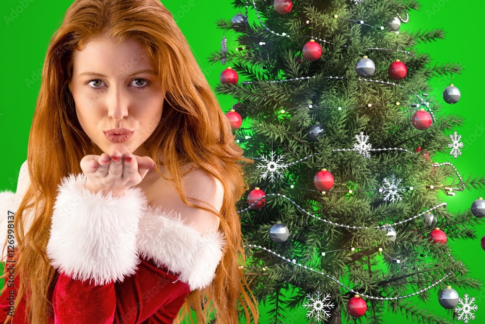 Portrait of beautiful woman in santa costume blowing a kiss