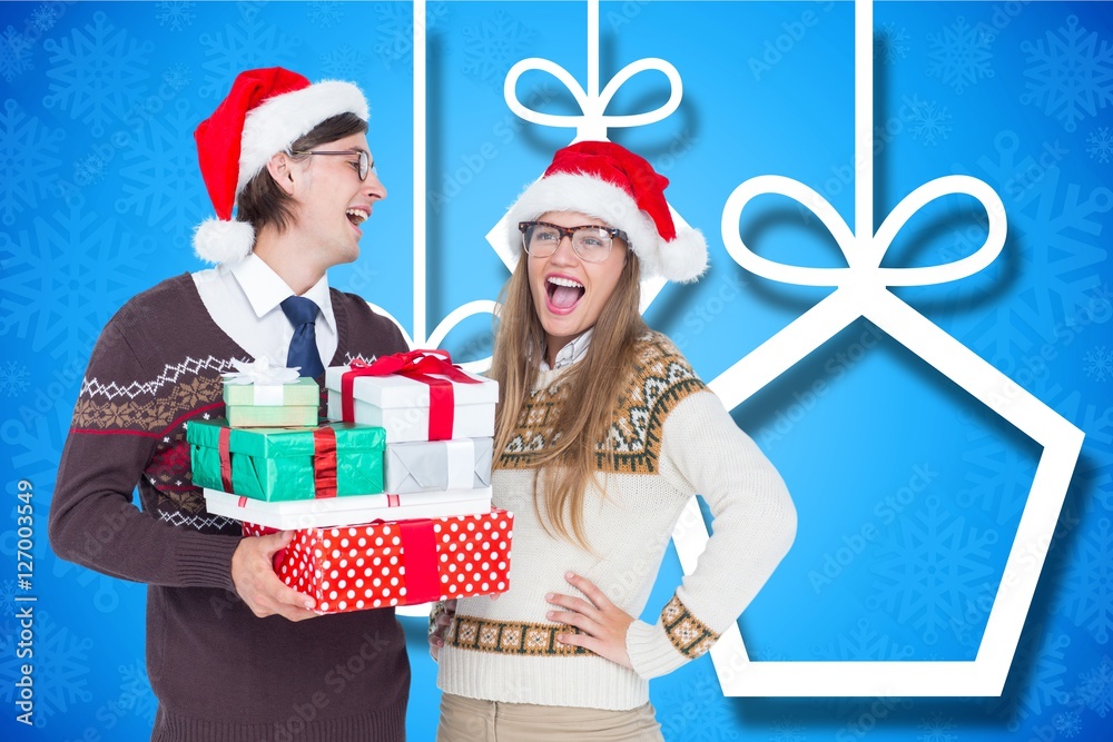 Happy couple in santa hat holding christmas gifts