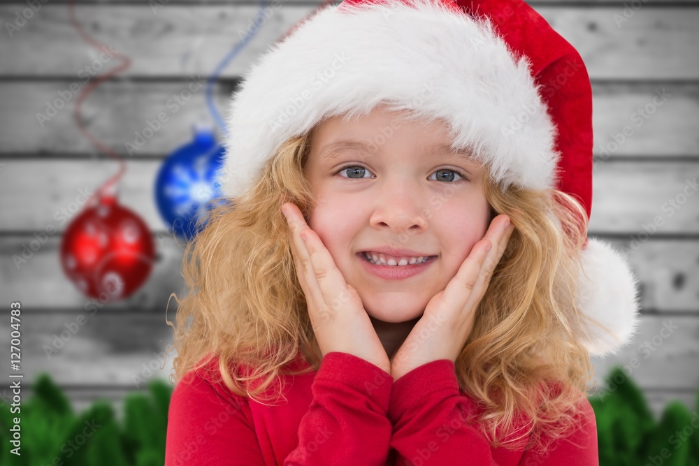 Little girl in santa hat smiling at camera