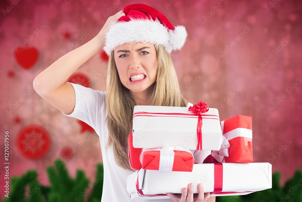 Frustrated woman in santa hat holding stack of gifts