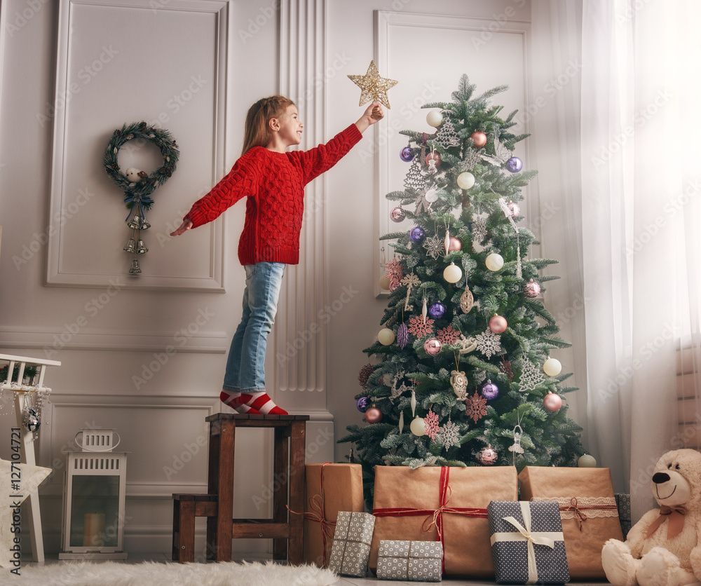 girl is decorating the Christmas tree