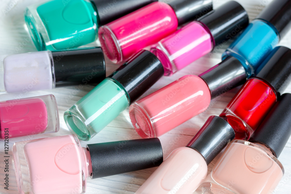 bottles of colored nail polish on wooden background