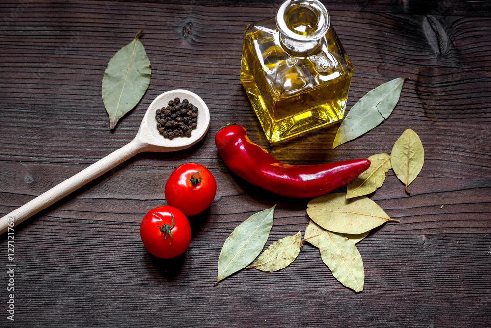 jar with oil and tomatoes on wooden background top view