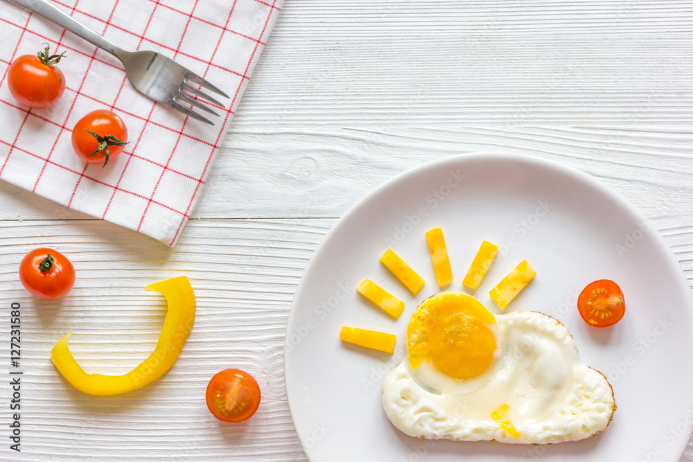 sunshine fried eggs breakfast for kid on wooden background