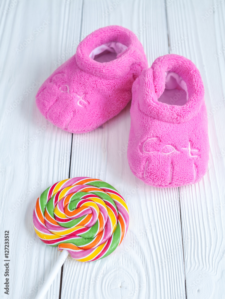 babys bootees and candy on wooden background