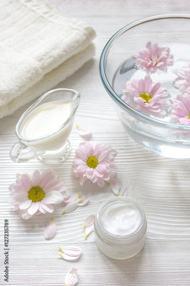 cream and spa on wooden background with flowers