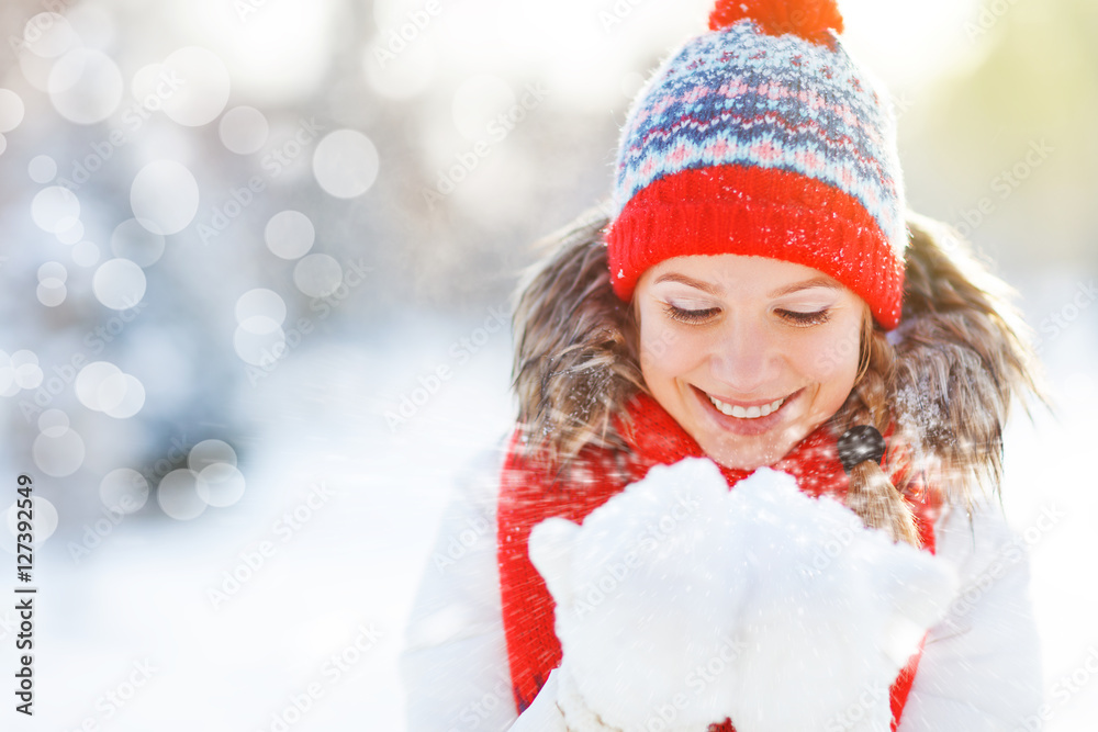 快乐的女人在冬天吹雪大自然