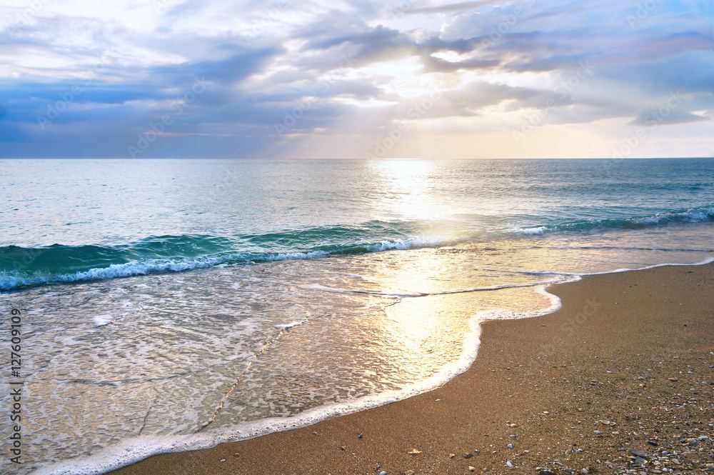 Dawn on the beach in summer. Sea sunset at the resort.  Beautiful calm wave of golden and azure colo