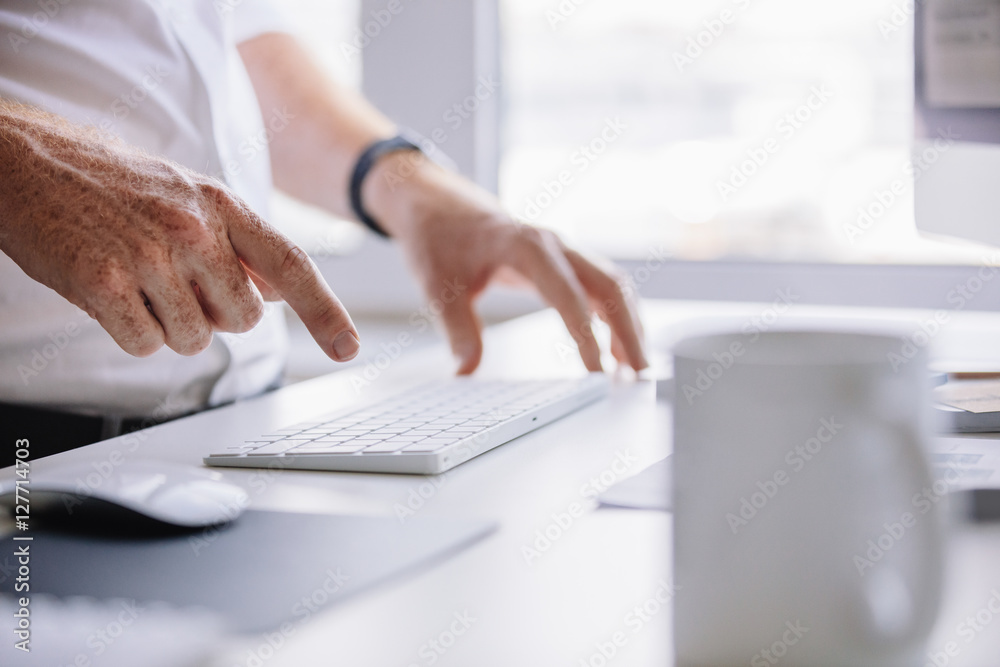 Young man hands typing on wireless keyboard