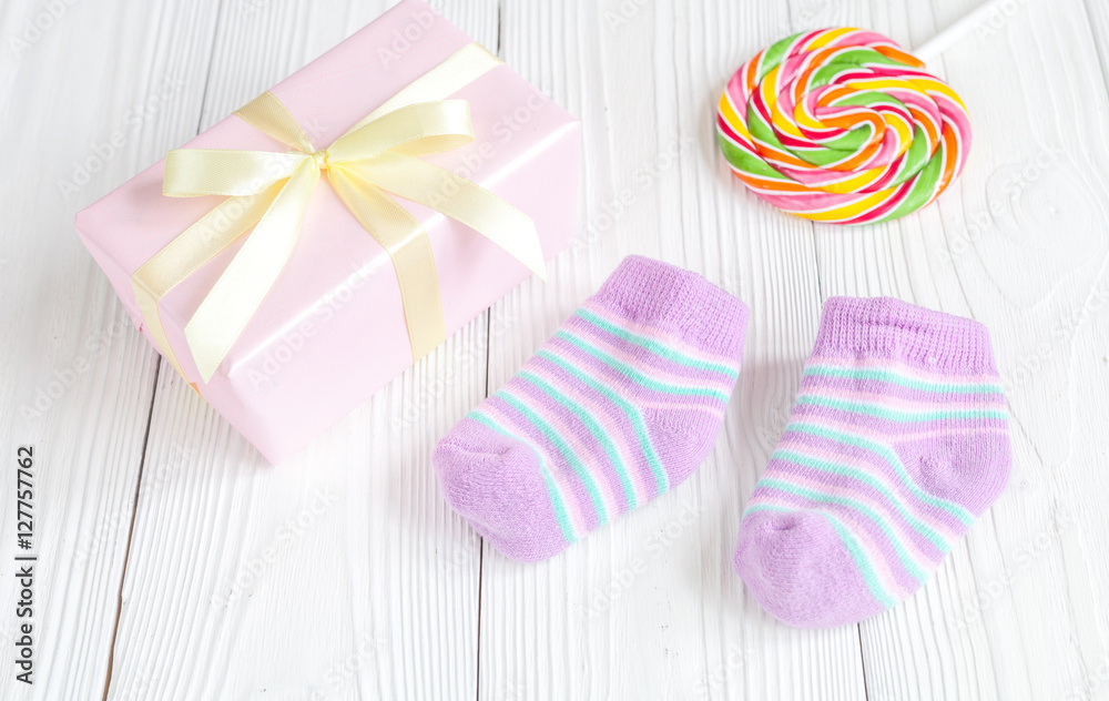 baby socks and gift box on wooden background