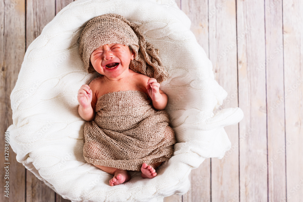 Crying baby boy in a basket