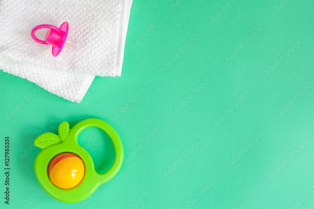 childrens clothes and baby booties on green background