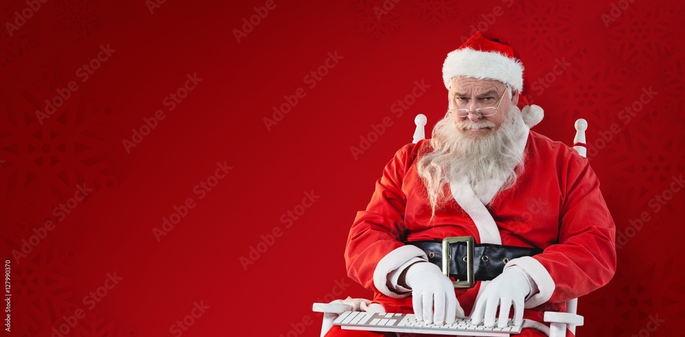 Composite image of santa claus typing on keyboard 