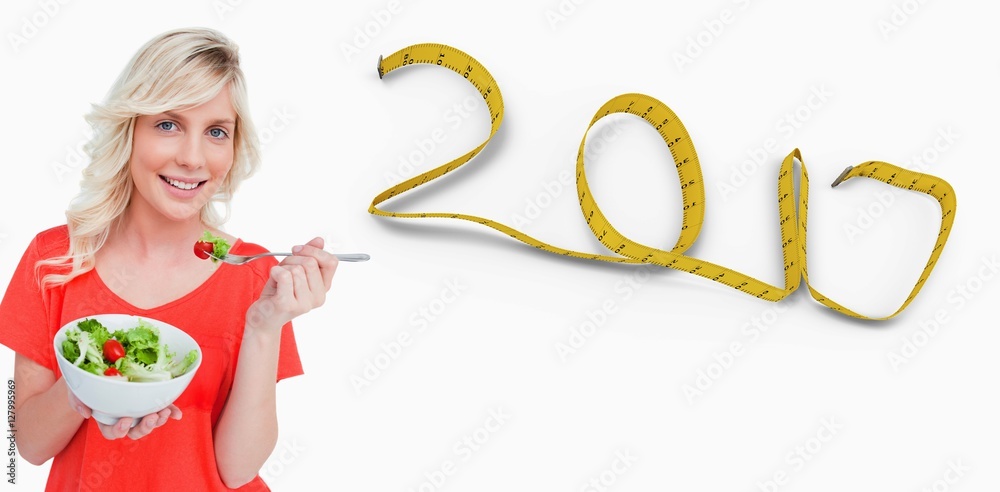 Composite image of young smiling woman eating a fresh salad with