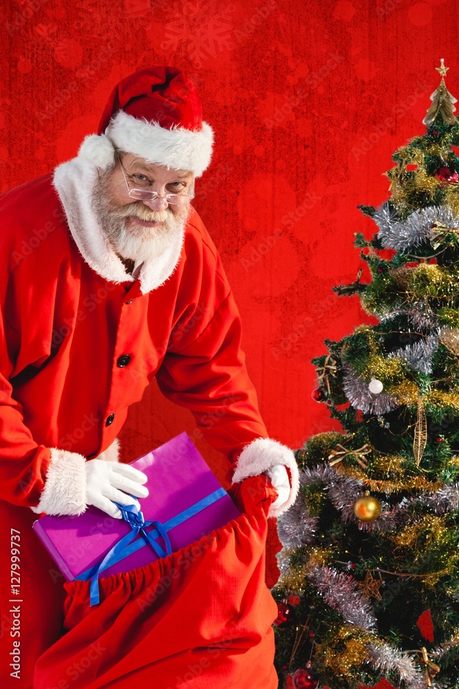 Composite image of santa claus putting presents in bag by christ