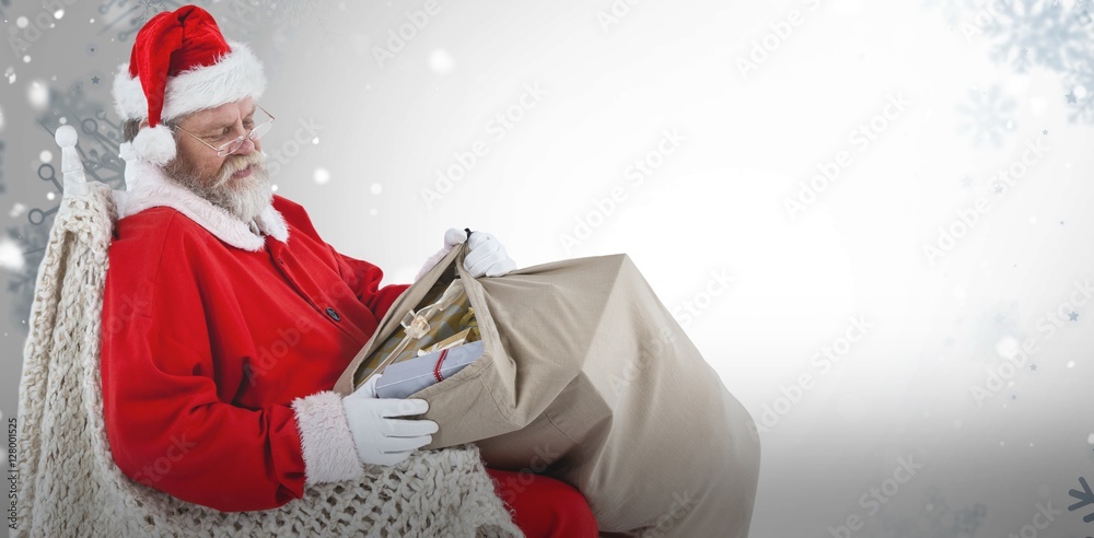 Composite image of santa claus sitting on chair and holding gift