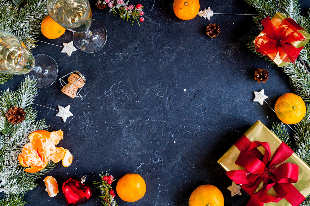 glasses and Christmas ornaments on dark background top view