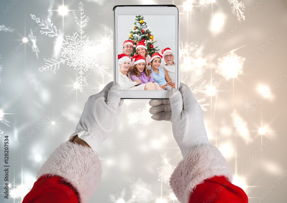 Santa claus holding a digital tablet with photo of christmas fam