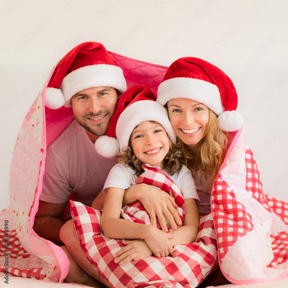 Happy family in bedroom. Mother, father and child indoors. People having fun at home.