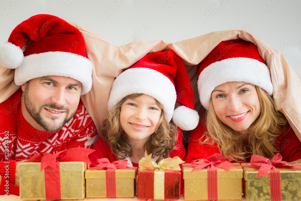 Happy family in bedroom. Mother, father and child indoors. People having fun at home.