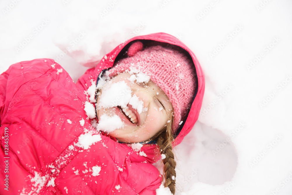 扎着辫子的顽皮女孩在初雪中玩耍