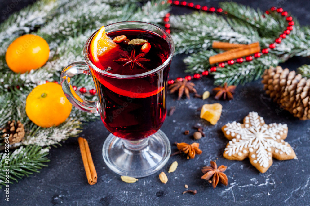 Christmas mulled wine with spices in cup on dark background