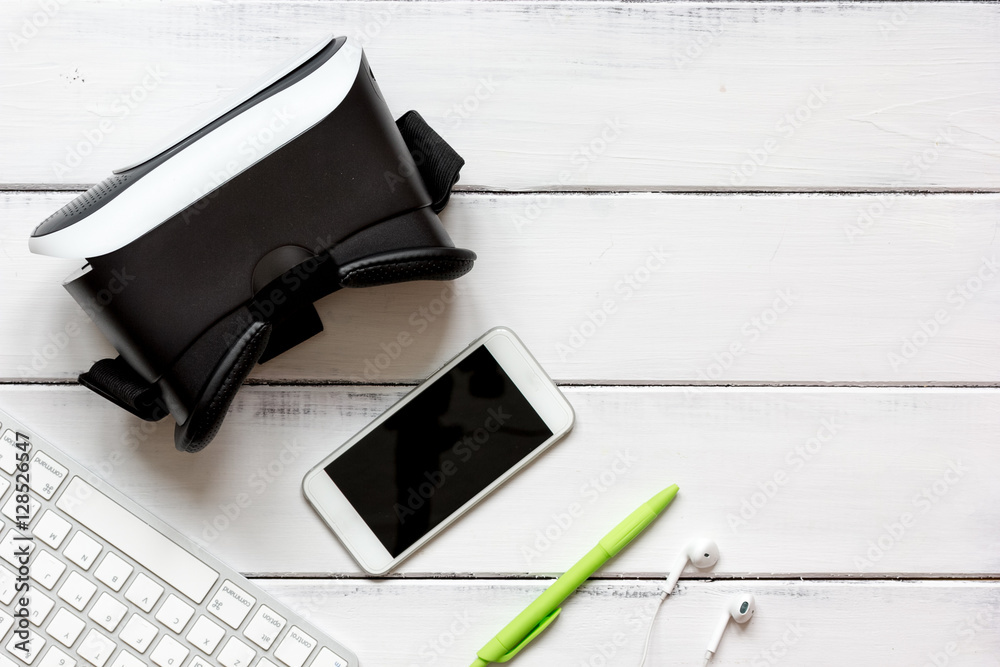 virtual reality glasses with smartphone, keyboard on wooden background