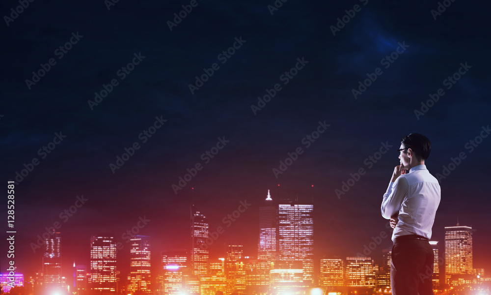 Businessman viewing night glowing city