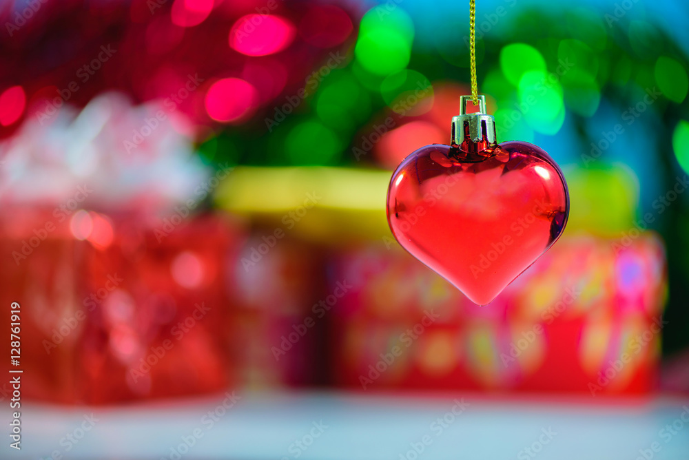 Christmas heart shaped red ball and blurred Christmas decoration