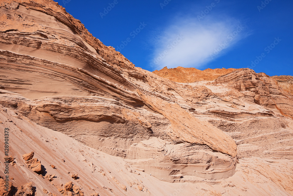 Layered sandy сool slope against the blue sky.