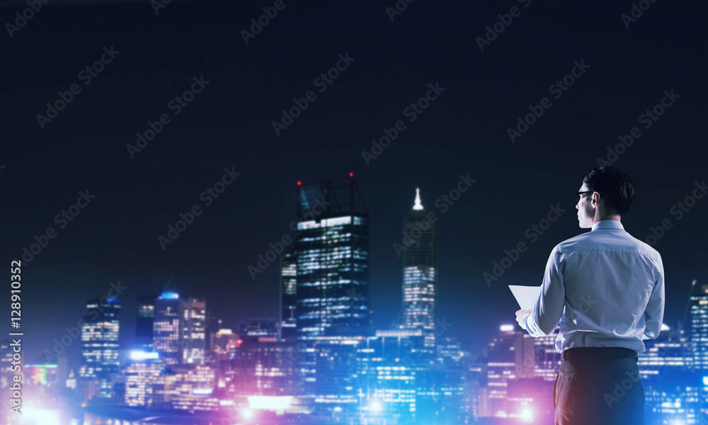 Businessman viewing night glowing city