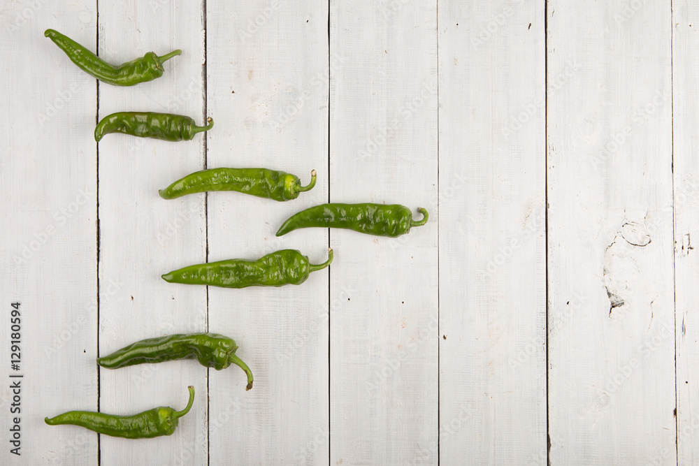 green pepperoni peppers on the wooden table