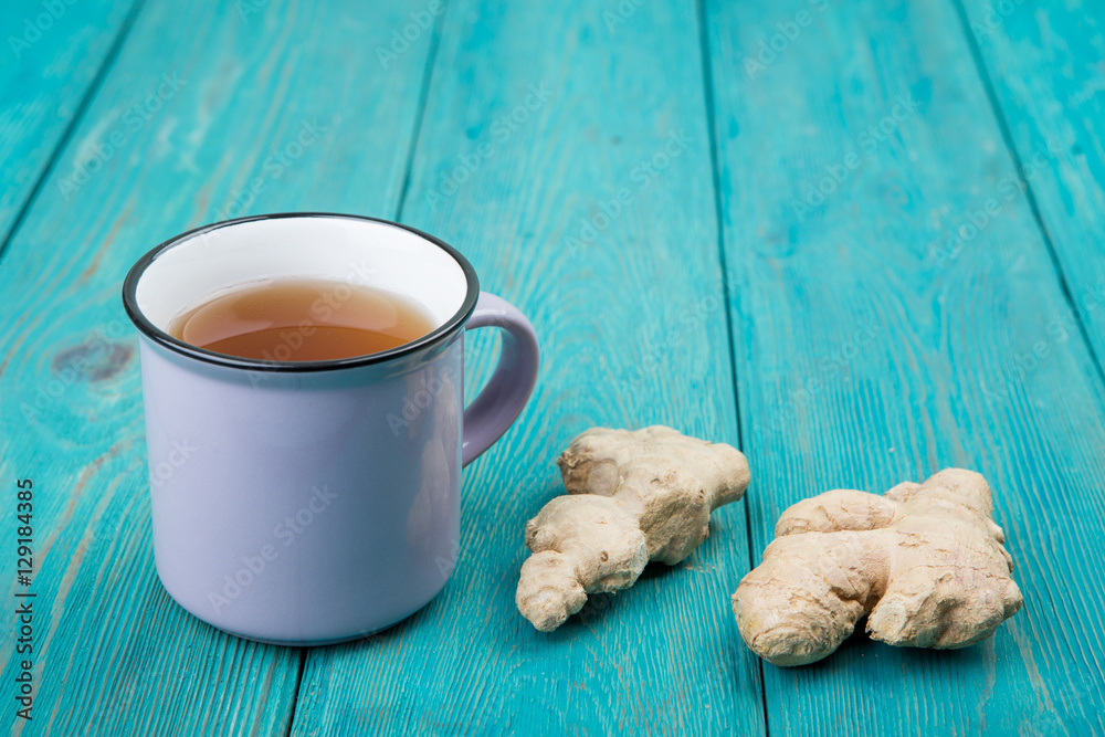 Ginger tea in a vintage cup on wooden background