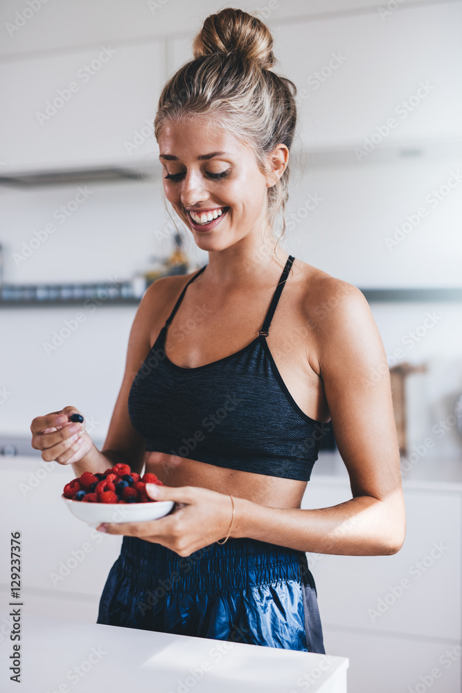 厨房里吃新鲜浆果的快乐女性