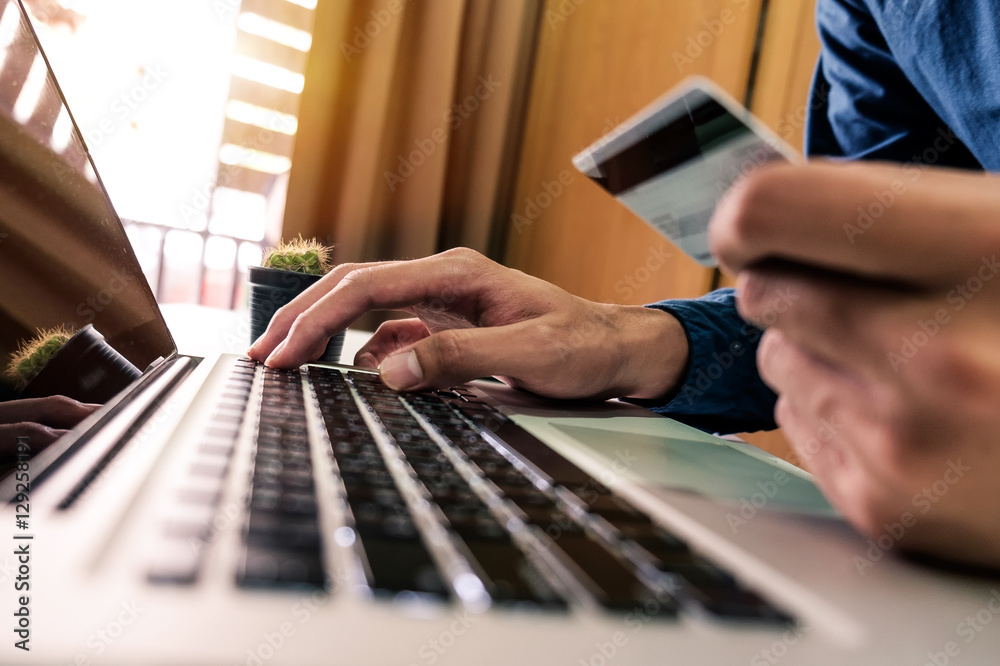 Man hands using laptop and holding credit card with social media as Online shopping concept in morni