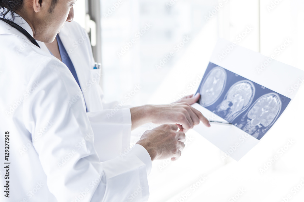 Doctors are talking while watching an X - ray picture at a hospital