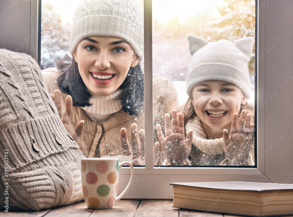 Child and mom looking in windows, standing outdoors