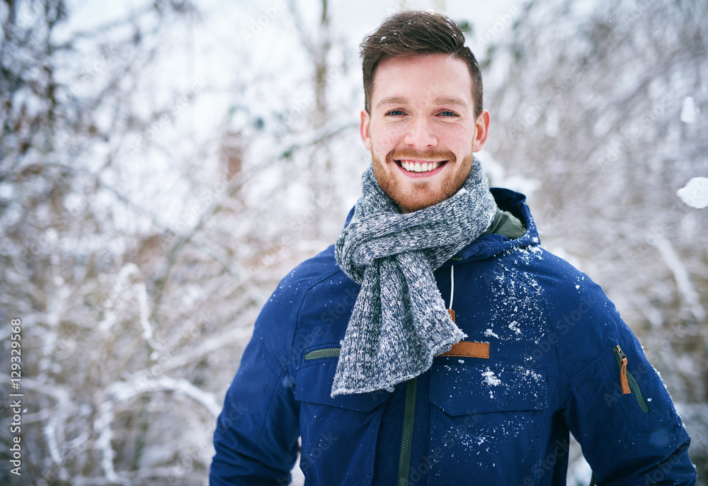 穿着外套的年轻人站在雪地里