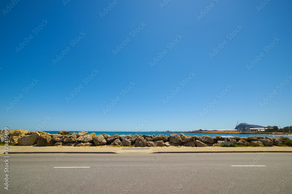 阳光明媚的夏日水边的柏油路