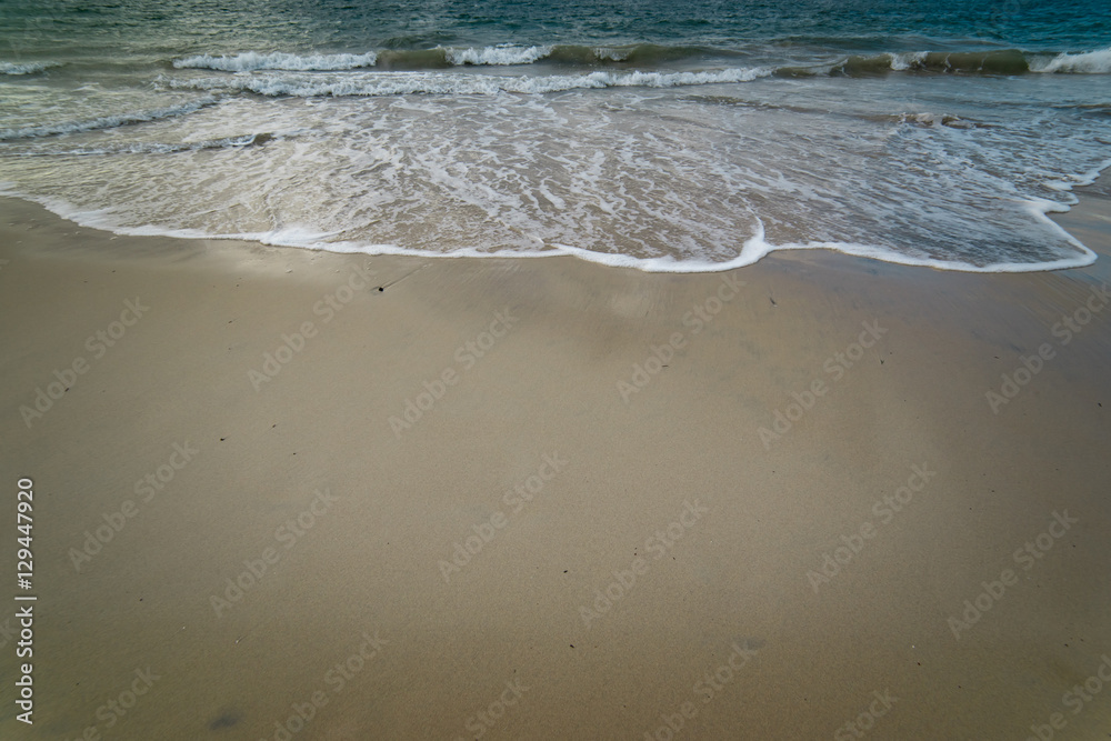 蓝色海洋在沙滩上的柔和波浪。背景。选择性聚焦。